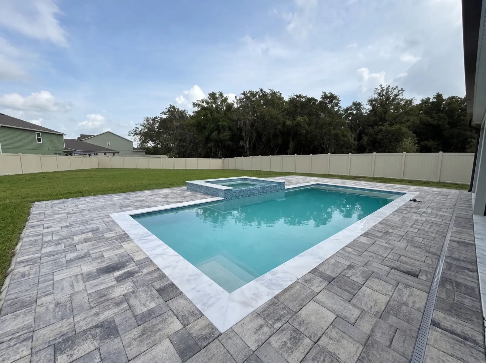 Completed Rock Maple Bend Residence pool and raised spa viewed from the covered patio